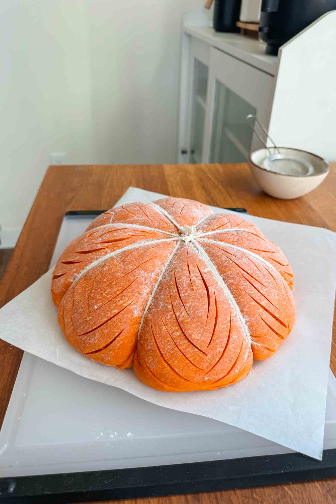 Pumpkin shaped dough scored and ready to bake.