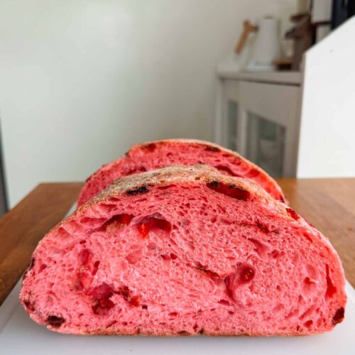Strawberry sourdough bread halves on cutting board